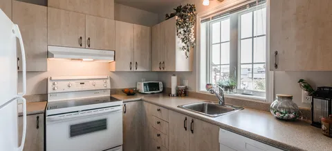 Suite kitchen with wooden cabinets and a window above the sink.
