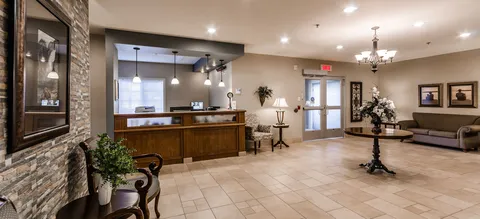 Lobby with tiled flooring, seating and a reception desk.
