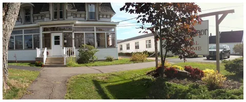 House entrance with steps, a covered porch, a front lawn and flower beds