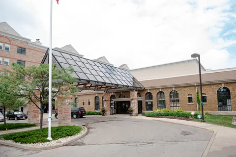 Residence buildings with a glass entrance canopy beside a curved driveway