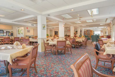 Wide dining room view with tables, chairs and bookcases.