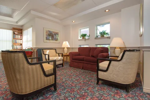 Seating area with sofas, armchairs and a bookcase.
