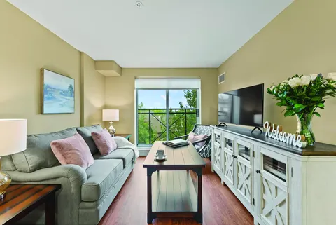 Sitting area with a sofa, television and glass balcony door