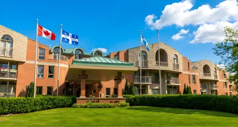Residence with arched windows, a covered entrance, flags and a front lawn