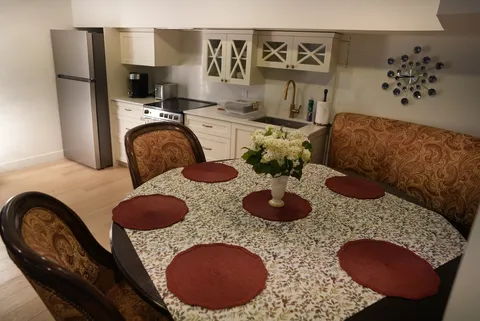 Kitchenette and dining table with upholstered chairs and a cushioned bench