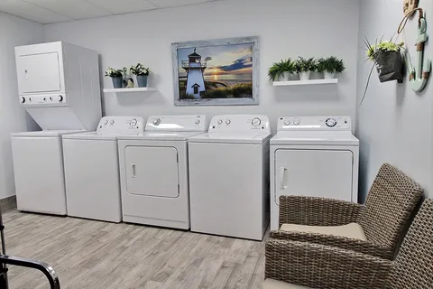 Laundry room with washers, dryers and storage cabinets.