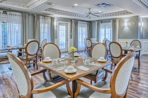 Dining room with set tables, pendant lights and large windows.