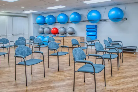 Exercise room with chairs, mats and fitness balls.