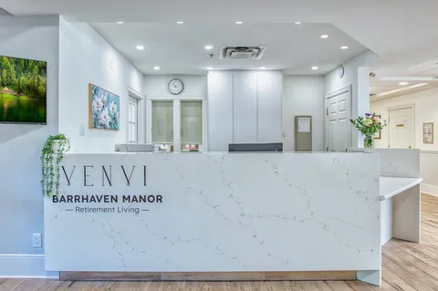 Reception counter with lift doors and seating behind it.