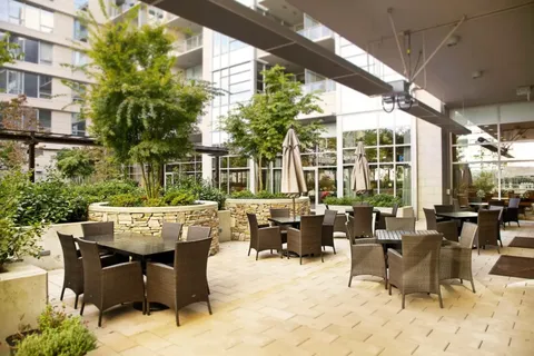 Patio with tables, chairs and umbrellas beside the residence