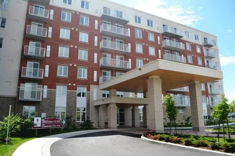 Multi-storey brick building with balconies and a covered entrance