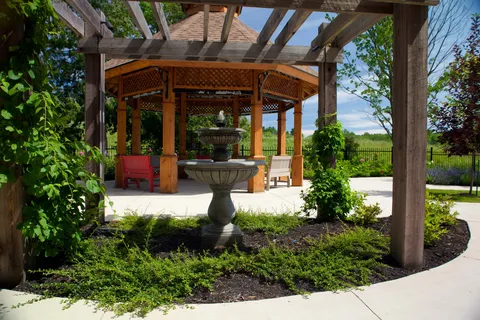 Garden with a tiered fountain, pergola, gazebo and benches.