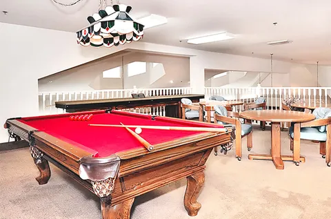Red billiards table beside tables and chairs on a mezzanine