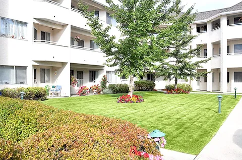 Lawn and flower beds in a courtyard surrounded by residential balconies