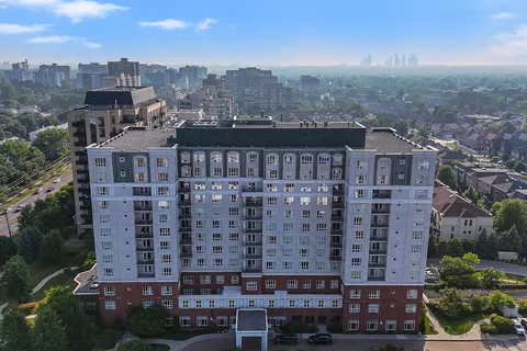 High-rise residence with balconies and an entrance canopy, viewed from above.