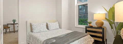 Bedroom with a bed, bedside lamps and a window