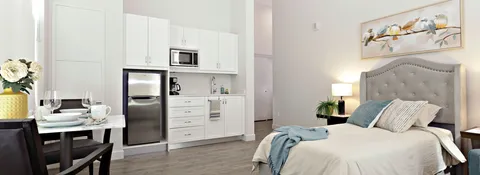 Bedroom with a bed, chairs and kitchenette