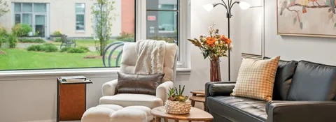 Sitting area with an armchair and sofa beside a large window