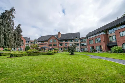 Residence exterior beside a lawn and paved walking path