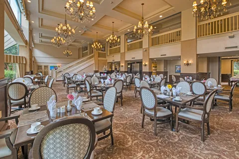 Dining room with set tables beneath chandeliers