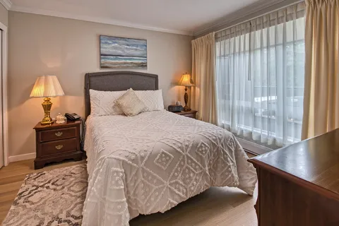 Bedroom with a bed, bedside lamps and sliding glass doors