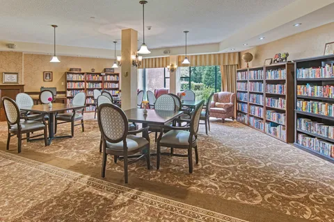 Library with bookshelves, round tables and large windows
