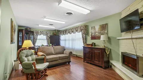 Room with a sofa, a rocking armchair, a fireplace and a blank television