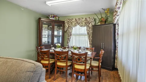 Room with a set dining table, six wooden chairs and glass-fronted cabinets