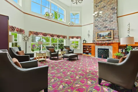 Room with armchairs, a fireplace and large windows