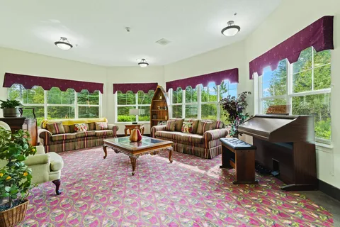 Room with patterned sofas, armchairs and a piano