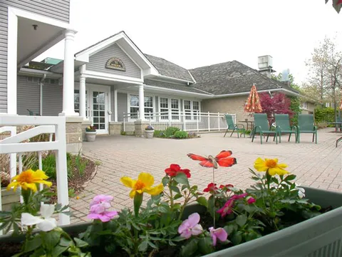 Flower beds beside a patio and the residence building.