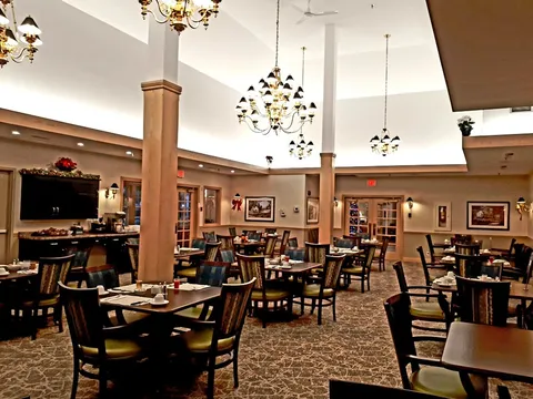 Dining room with tables, chairs and chandeliers.