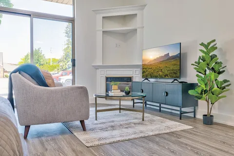 Suite living room with an armchair, television and fireplace.