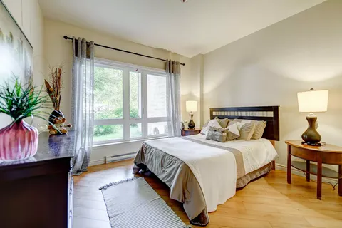 Bedroom with bedside tables, lamps and a large window