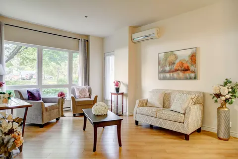 Sitting room with a sofa, armchairs, coffee table and large windows