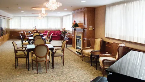 Lounge with tables, upholstered chairs, a piano and a fireplace