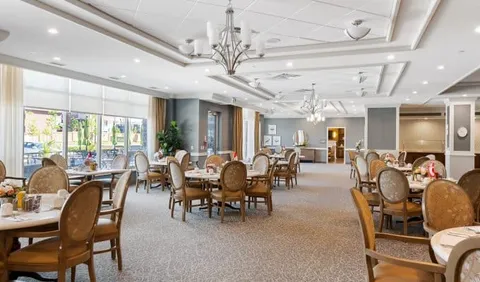 Dining room with round tables, upholstered chairs and chandeliers