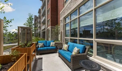 Patio with blue cushions, wicker chairs and raised planters
