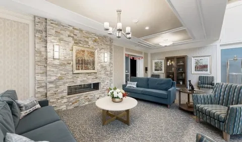 Room with blue sofas and armchairs around a stone fireplace