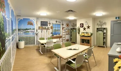 Room with tables, chairs, cabinets and a waterfront mural