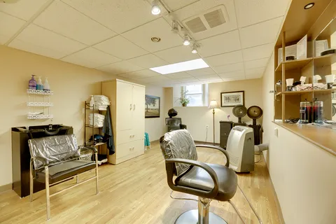 Hair salon with styling chairs, wash basins and hood dryers