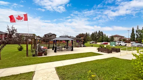 Garden with a pergola, benches, flower beds and a lawn