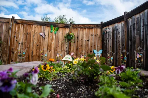 Fenced flower garden with hanging baskets and butterfly decorations
