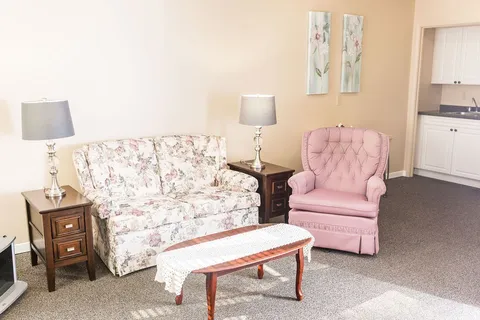Suite living area with a sofa, armchairs and a television.