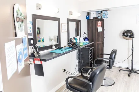 Salon with styling chairs, mirrors and a hair dryer.