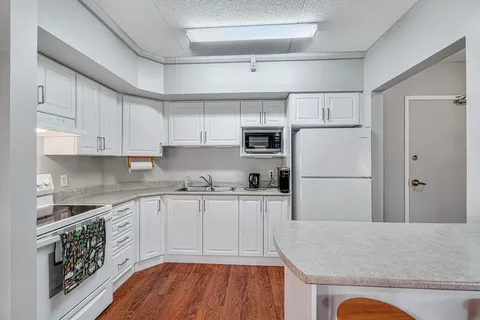 White kitchenette with refrigerator, stove and microwave