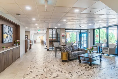 Seating area with a sofa, armchairs and large windows