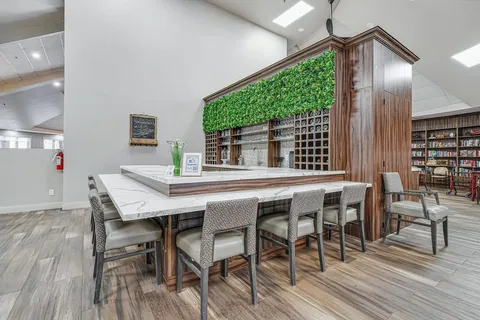 Counter with stools beneath a green wall panel