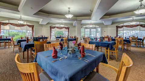 Dining room with tables and wooden chairs.