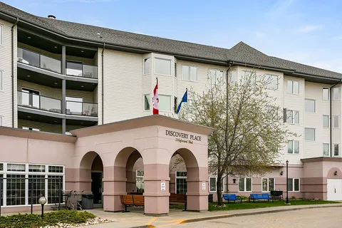 Residence facade with balconies and an arched main entrance.
